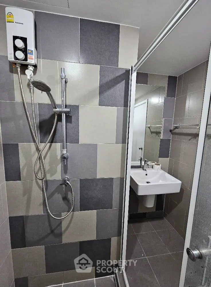Modern bathroom with sleek shower and stylish tiles in contemporary apartment.