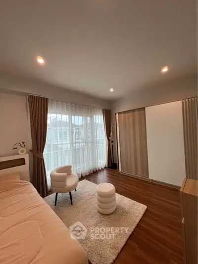 Spacious modern bedroom with elegant decor and large window for natural light.