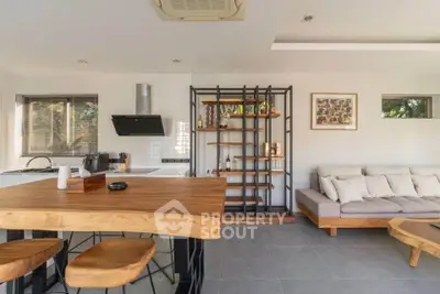 Modern open-plan kitchen and living room with stylish wooden furniture and natural light.