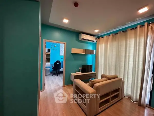 Modern living room with teal walls, cozy sofa, and wall-mounted TV unit.