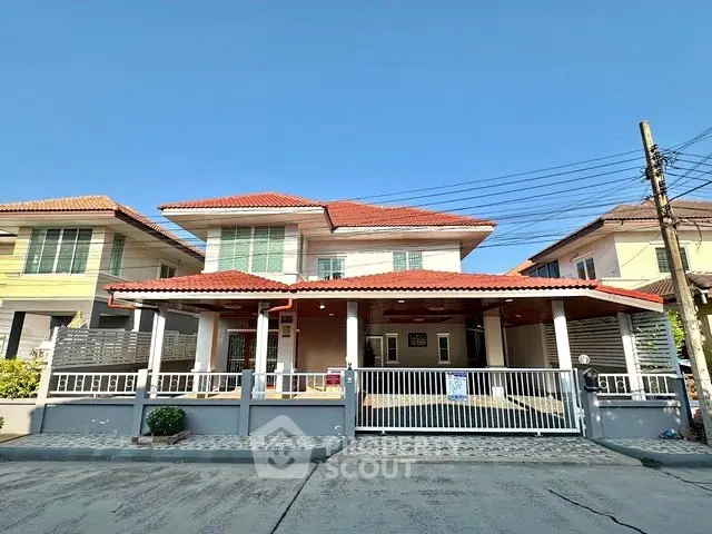 Charming two-story house with red-tiled roof and spacious driveway in a serene neighborhood.