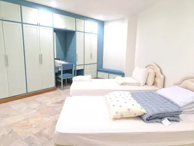 Spacious bedroom with twin beds and ample closet space in modern home.