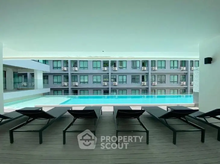 Luxurious poolside view with modern apartment backdrop, perfect for relaxation and leisure.