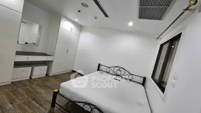 Spacious bedroom with modern furnishings and ample storage in a well-lit apartment.