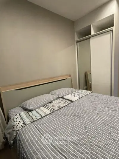 Cozy bedroom with modern decor and mirrored closet doors.