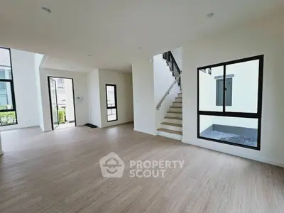 Spacious modern living room with large windows and wooden flooring