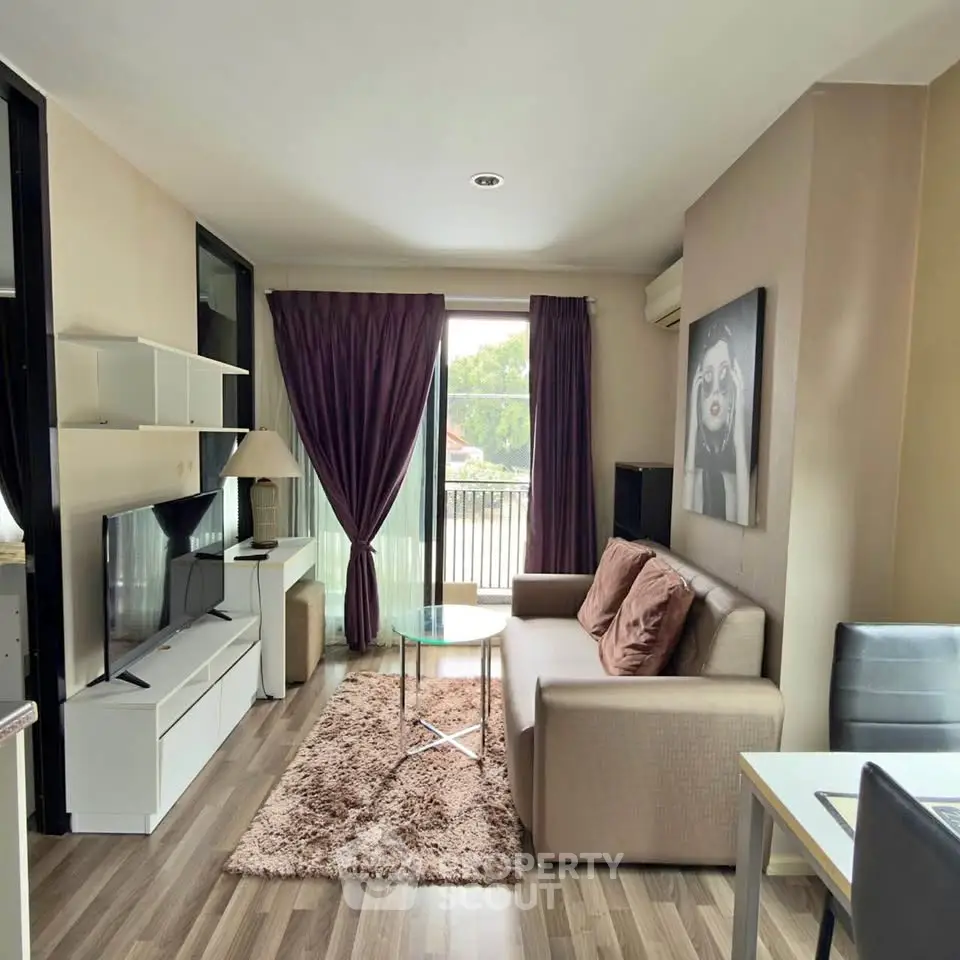 Modern living room with stylish decor and natural light, featuring a cozy sofa and entertainment center.
