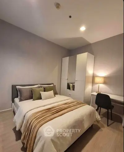 Cozy bedroom with modern decor, featuring a comfortable bed, stylish wardrobe, and a functional study desk.