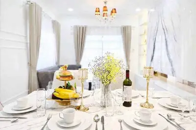 Elegant dining room with marble table, luxurious decor, and bright natural lighting.
