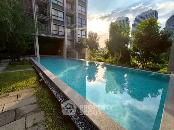 Luxurious apartment building with stunning infinity pool and lush greenery, perfect for serene living.