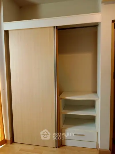 Spacious built-in wardrobe with sliding doors and ample storage space in modern apartment.