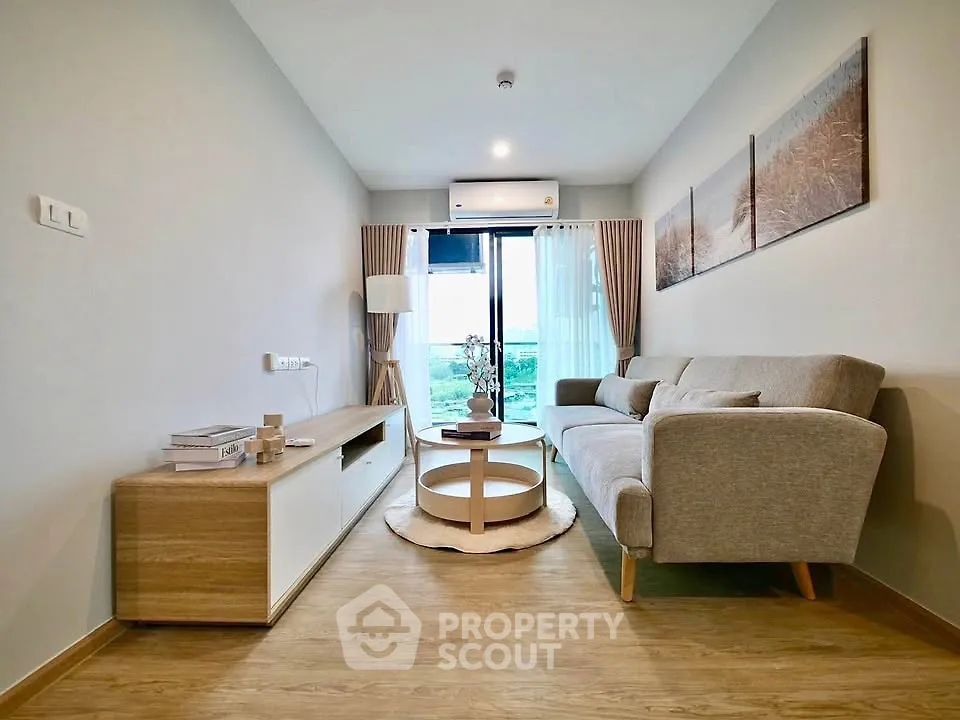 Modern living room with stylish furniture and large window offering natural light and scenic view.