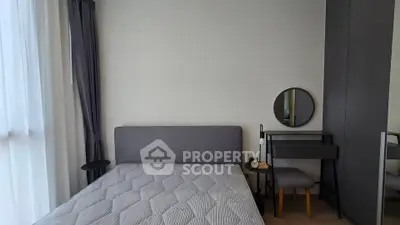 Modern bedroom with stylish decor and natural light, featuring a cozy bed and elegant furniture.