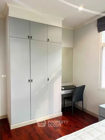 Elegant bedroom with built-in wardrobe and cozy study nook
