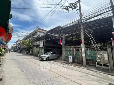 Commercial building with parking space on a busy street, ideal for business opportunities.