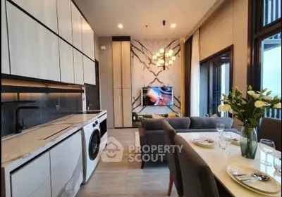 Modern open-layout living room with sleek kitchen, washing machine, and elegant dining area.