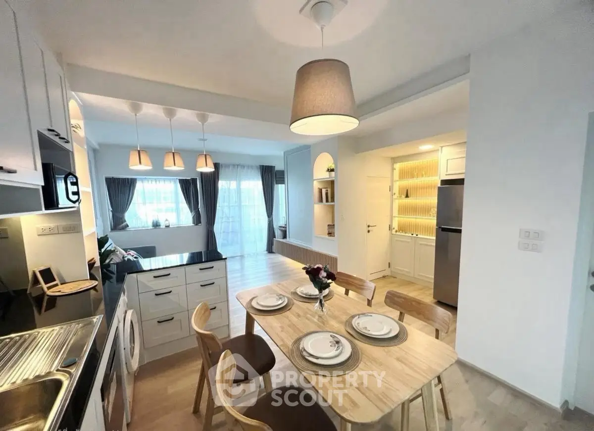 Modern open-layout kitchen and dining area with elegant lighting and stylish decor.