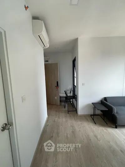 Modern living room with sleek furniture and air conditioning, featuring a cozy seating area and stylish decor.