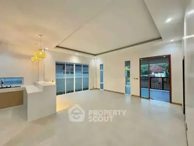 Spacious modern living room with open layout and large windows in a contemporary home.