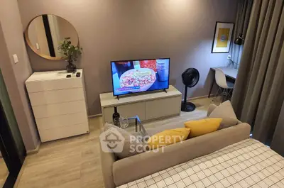 Modern living room with stylish decor, featuring a cozy sofa, flat-screen TV, and a chic workspace.
