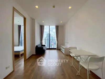 Modern living room with city view, wooden flooring, and minimalist furniture in a high-rise apartment.