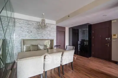 Elegant dining area with chandelier and mirrored wall in modern apartment