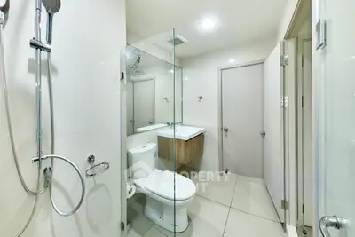 Modern bathroom with glass shower and sleek fixtures in a contemporary home.