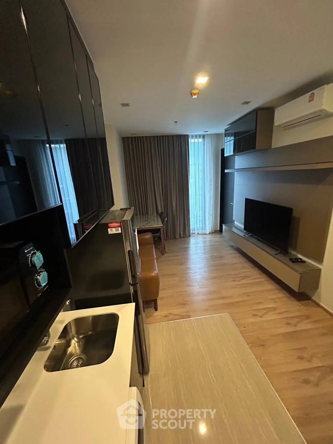 Modern living room with sleek design, featuring a wall-mounted TV and stylish furniture.