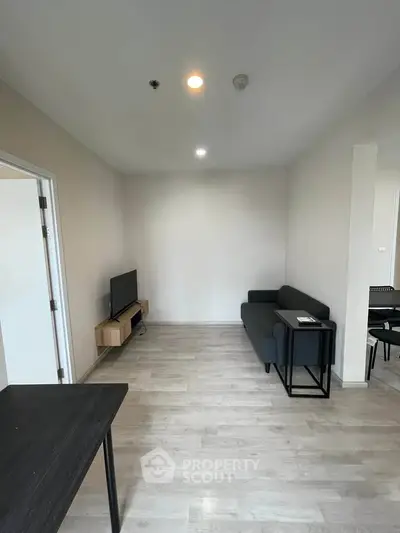 Modern living room with minimalist furniture and sleek wooden flooring.
