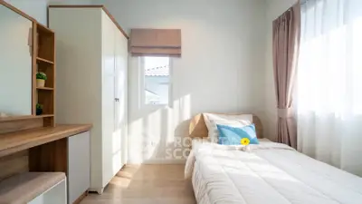 Bright and cozy bedroom with natural light, featuring a single bed, wardrobe, and a window view.