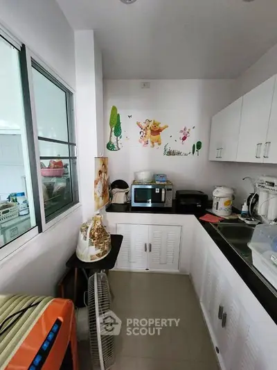 Charming kitchen with modern appliances and playful wall decor, perfect for family gatherings.