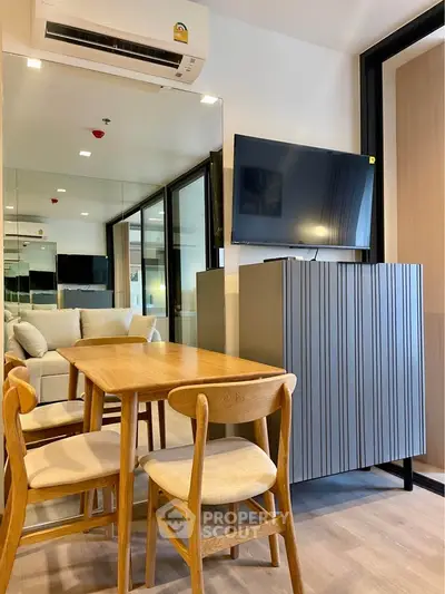 Modern living room with sleek furniture and wall-mounted TV in a stylish apartment.
