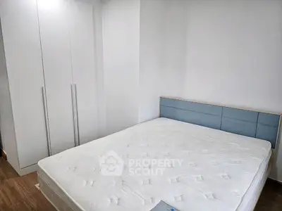 Modern bedroom with minimalist design featuring a comfortable bed and sleek wardrobe.