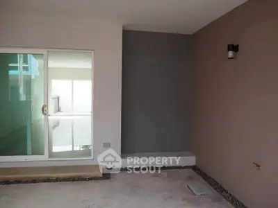 Modern minimalist patio with sliding glass doors and sleek wall light fixture.