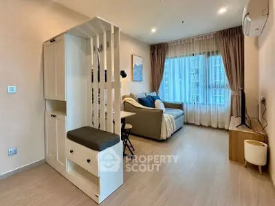 Modern living room with cozy sofa, stylish decor, and large window offering natural light in a contemporary apartment.