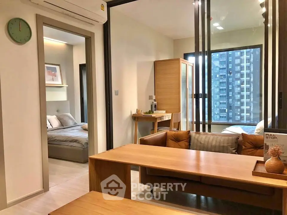 Modern apartment interior with cozy living room and bedroom, featuring stylish furniture and large windows.