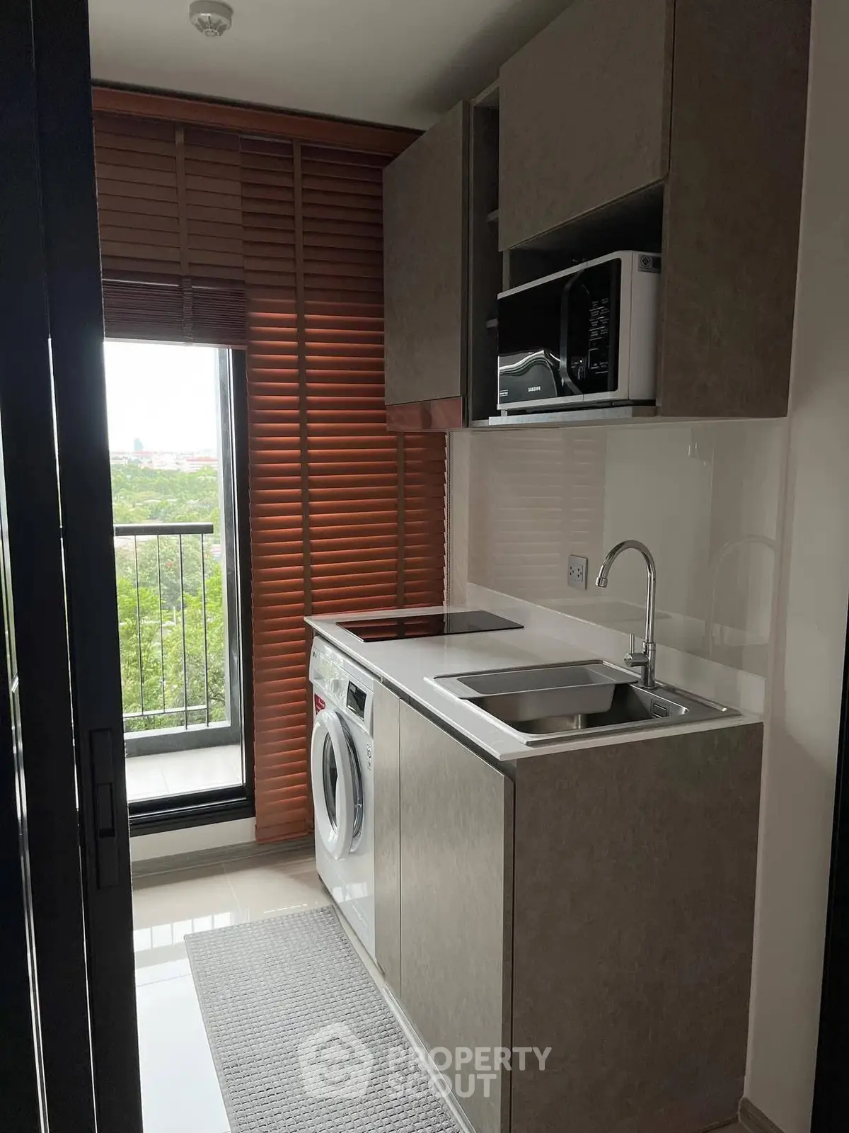 Modern compact kitchen with washing machine and balcony view