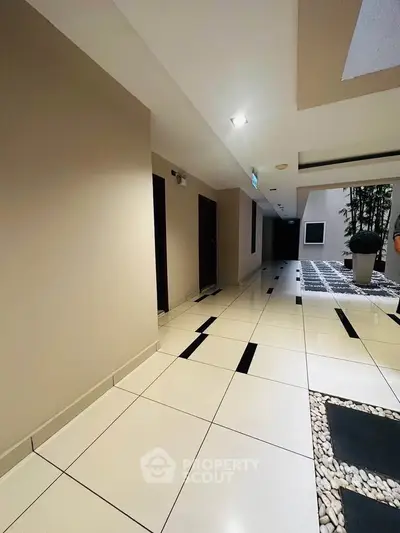 Modern apartment building hallway with sleek tile flooring and stylish decor.