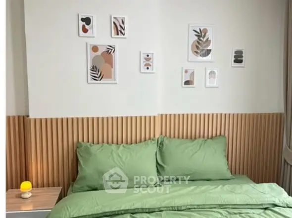 Cozy bedroom with modern decor and green bedding, perfect for relaxation.