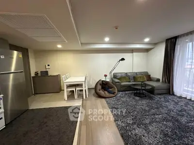 Spacious modern living room with open layout, featuring cozy seating and dining area, perfect for entertaining.