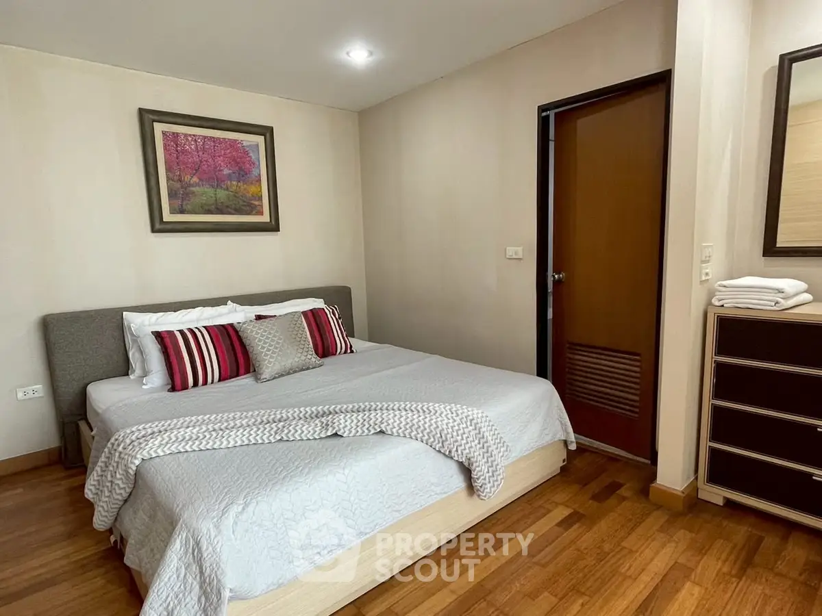 Cozy bedroom with wooden flooring and stylish decor in modern apartment