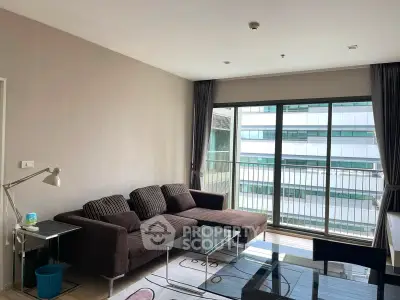 Modern living room with large windows and stylish furniture in a high-rise apartment.