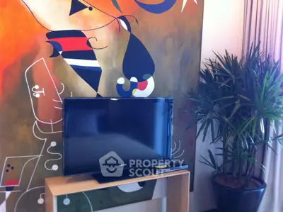 Stylish living room with modern art and TV setup, perfect for relaxation and entertainment.