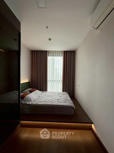 Modern bedroom with sleek design and ambient lighting, featuring a cozy bed and elegant curtains.
