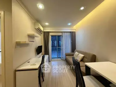 Modern living room with sleek furniture and balcony access, perfect for urban living.