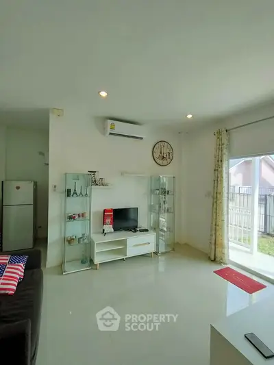 Bright living room with modern decor and large window overlooking garden