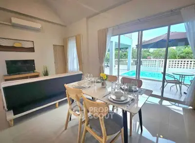 Modern living room with pool view, stylish dining area, and natural light.