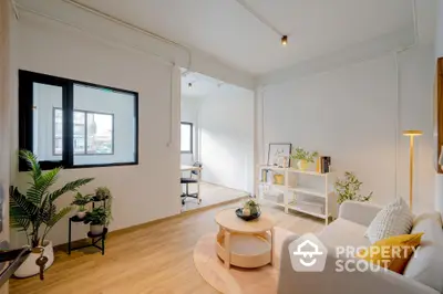 Bright and airy living room with modern furnishings, large windows, and wooden flooring, ideal for comfortable urban living.