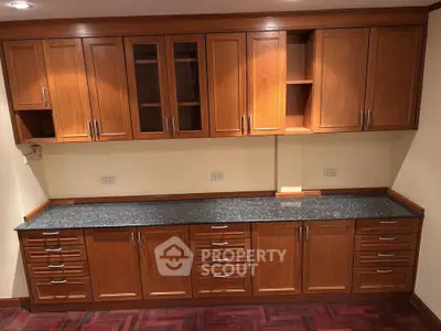 Elegant wooden kitchen cabinets with granite countertop in a modern home interior.
