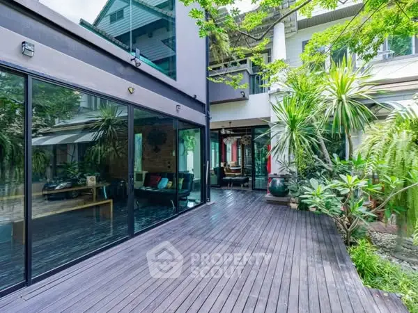 Stunning modern home with spacious wooden deck and lush greenery